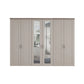 A six-door Wiemann Truro wardrobe with four solid doors and two mirrored doors in the center, finished in a light beige wood tone with slim silver handles.