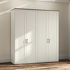 A tall white four-door Wiemann Truro wardrobe or closet with a natural wood top and slim black metal handles, shown in a real room with beige walls, wood flooring, and soft window shadows.